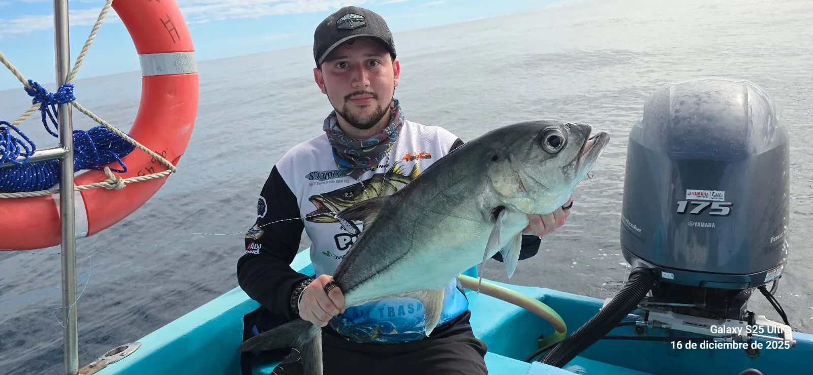 Persona sosteniendo un pez a bordo de una embarcación