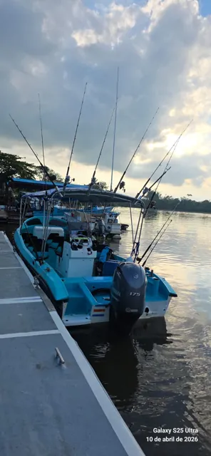 Embarcación con cañas de pesca junto al muelle