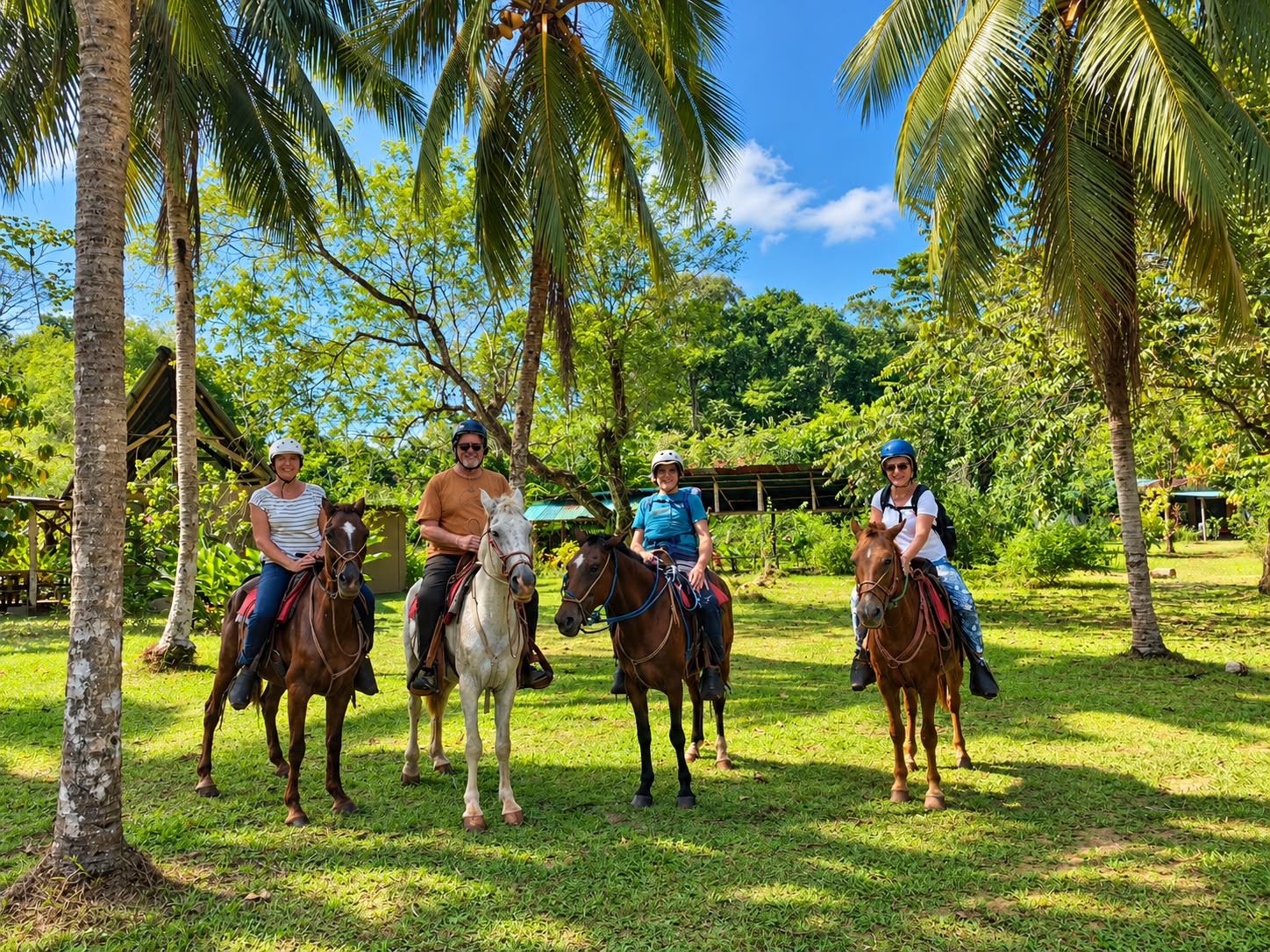 Grupo de viajeros a caballo entre palmeras